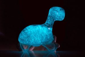 Plastic dinosaur filled with water and phytoplankton that are bioluminescently glowing blue