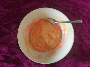 Picture of a bowl of custard with swirls of bright pink running through it