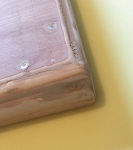 Part-sanded wood filler on corner of kinky DIY table top