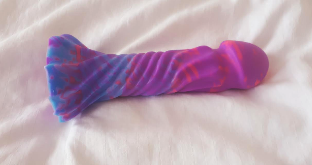 Thick pink/blue/purple dildo with a spiral texture running up the shaft