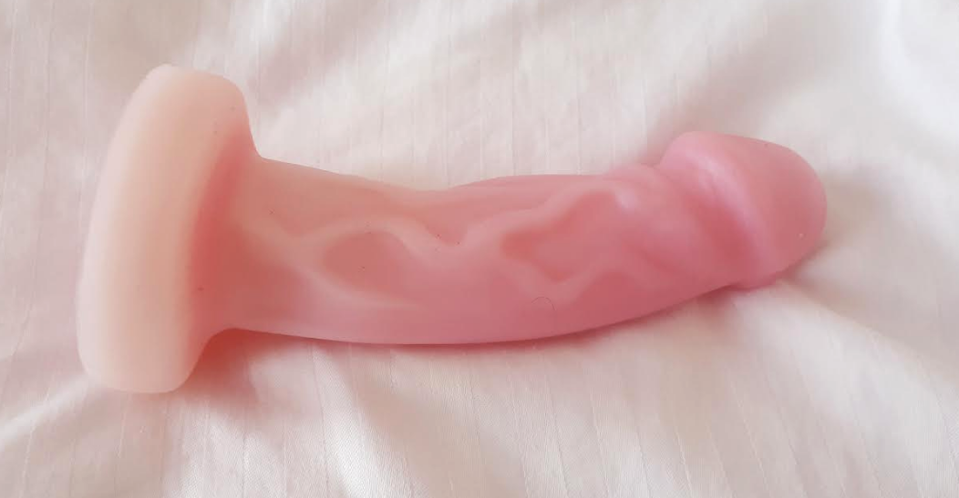 Soft pink, veined/textured dildo with a curve in it