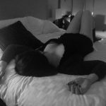 Woman lies on back on the bed, in a top and knickers
