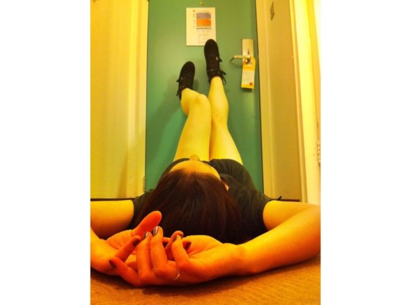 woman lying on her back with her legs leaning up against the wall