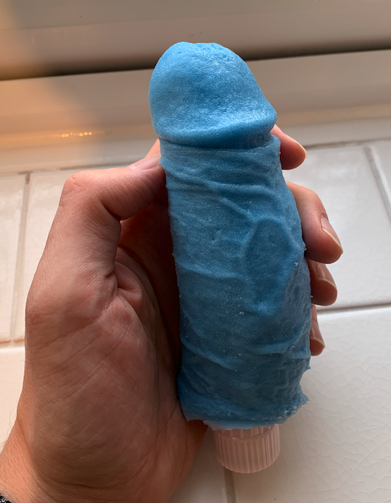 Blue veined silicone vibrator, held in a hand, that is an accurate representation of a real life dick