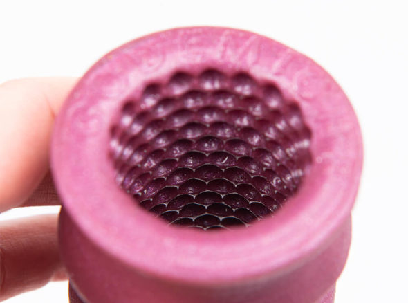 Pink masturbation sheath, open at both ends, with small concave dimples on the inside of the sheath