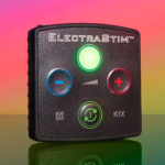 Image of the ElectraStim KIX control unit - a green light, red blue and green buttons, on a black box on rainbow background
