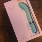 Image of white box with the teal, curved g-spot vibe the Pillow Talk Sassy inside it. The box proudly boasts that it 'dazzles with Swarovski crystal'