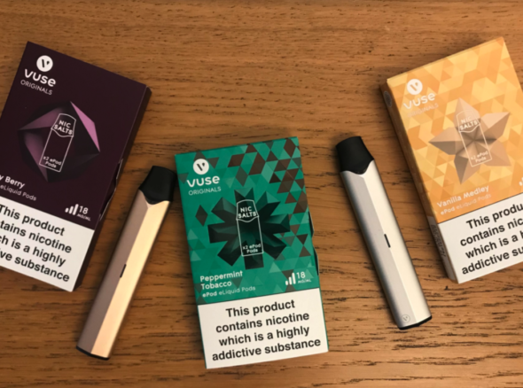 Two metallic epod vape sticks with a selection of flavoured pods to put in them