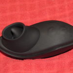 Image of the Control Rim Joy By Sir Richard's, a black handheld sex toy with a raised 'lip' that contains a black tongue-shaped protrusion