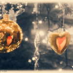 Close-up on gold baubles hanging from a Christmas tree - in the baubles you can see the reflection of a sexy lady's bum clad in festive red knickers
