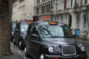 Generic shot of a few black cabs with orange lights on waiting on a London street