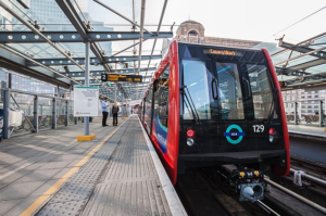 Shot of a red, square DLR train pulling in at a station