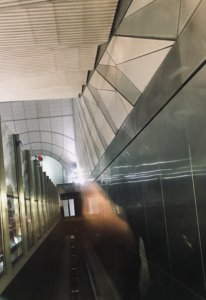 Dodgy photo from inside a lift showing a diagonal lift shaft falling away through the glass doors