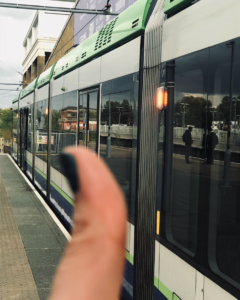 Green tram car parked in Wimbledon station, GOTN thumb up in foregroudn