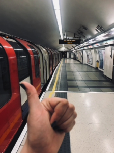 Empty platform on the underground with classic UG train at station and sign that says 'next train this platform'