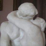 Close-up of marble statue by Rodin 'the kiss' where two lovers are locked in a passionate embrace and kiss, white marble