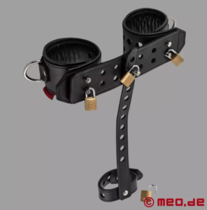 Leather strap with two thick wrist restraints attached, with lockable padlocks. In the middle there's a short strap hanging down attached to another lockable restraint, this one designed to hold the cock and/or balls