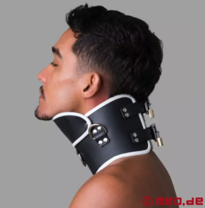 Side-on view of a man wearing a black leather posture collar to keep his neck straight, padlocked twice at the back and with white trim
