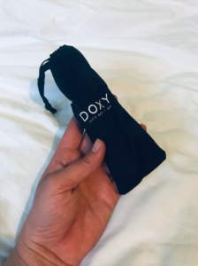 Small black pouch with 'Doxy, let's get it on' written in white lettering