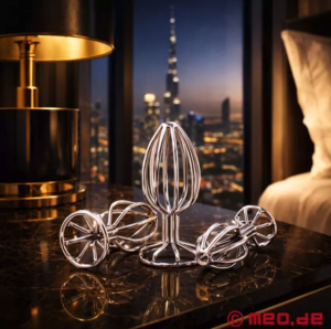 On top of a table, three different-sized butt plugs each made of a 'cage' of metal, hollow inside