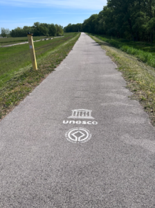 Smooth concrete path with 'UNESCO world heritage site' spray painted on it in white